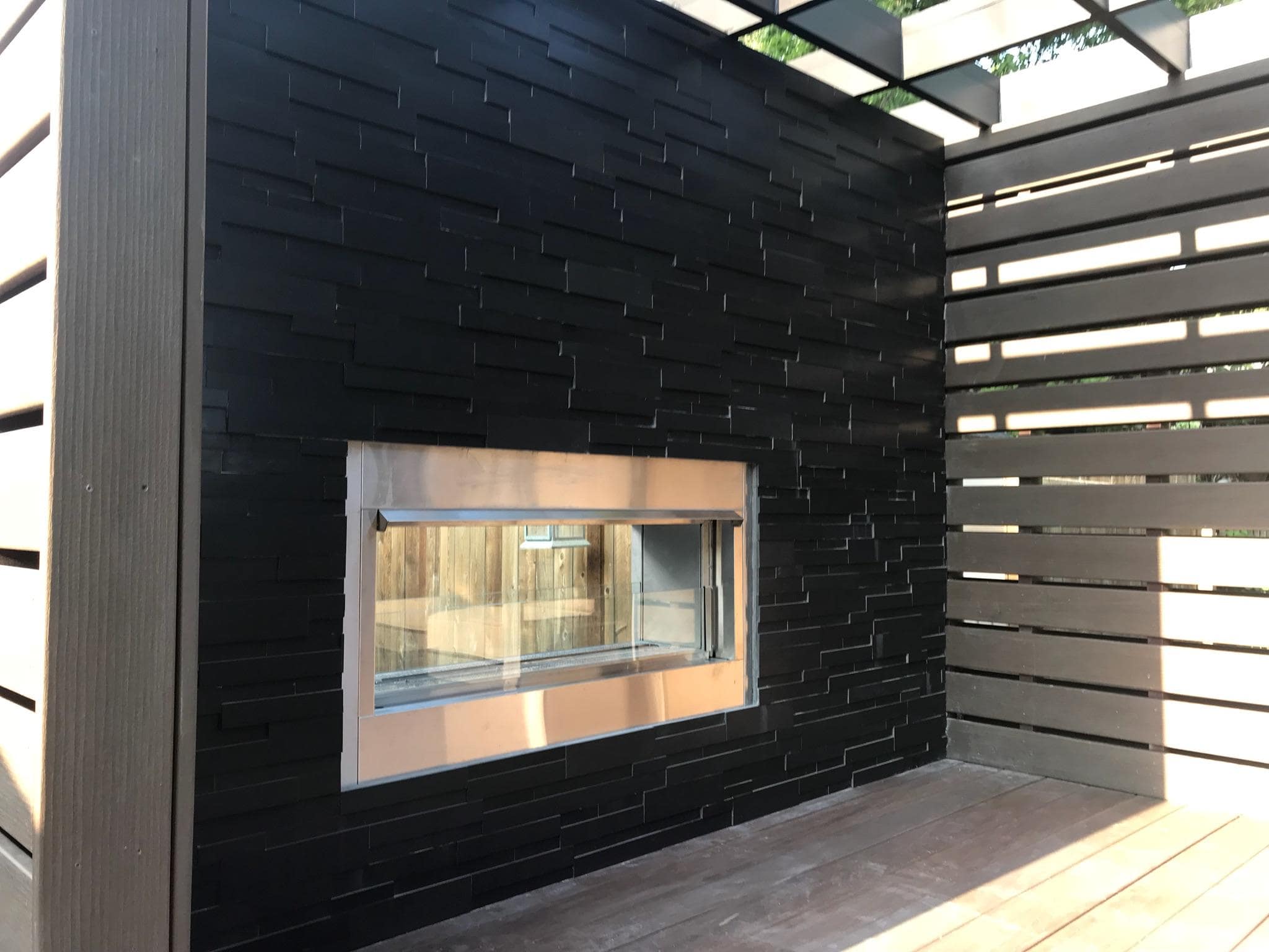 Norstone Ebony Aksent 3D Panels used on an outdoor two sided fireplace in a unique private outdoor room